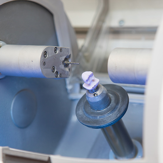 Dentist taking crown out of the CEREC machine