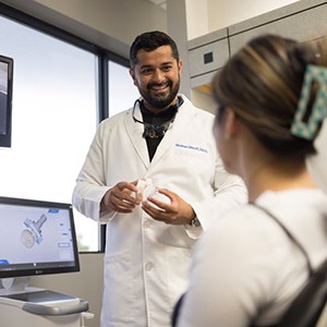 Dentist discussing treatment options with patient wearing blue hairclip