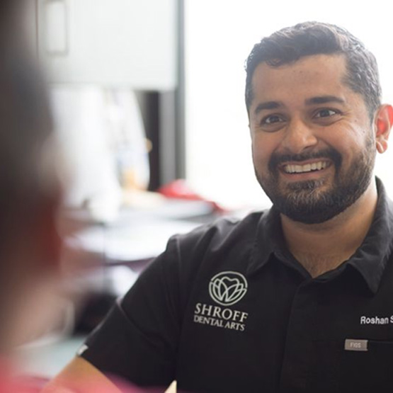 Dr. Shroff smiling while talking to a patient
