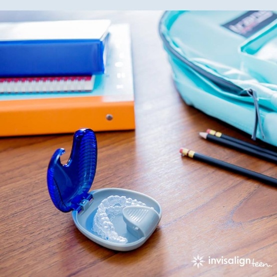 Invisalign in case on desk next to school supplies