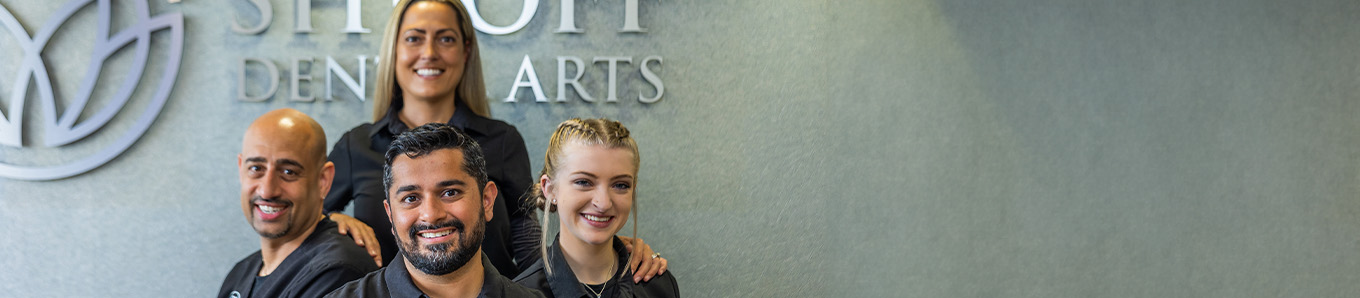 Dental patient smiling at dentist and assistant