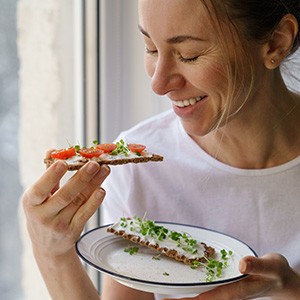 Smiling woman while eating healthy snack