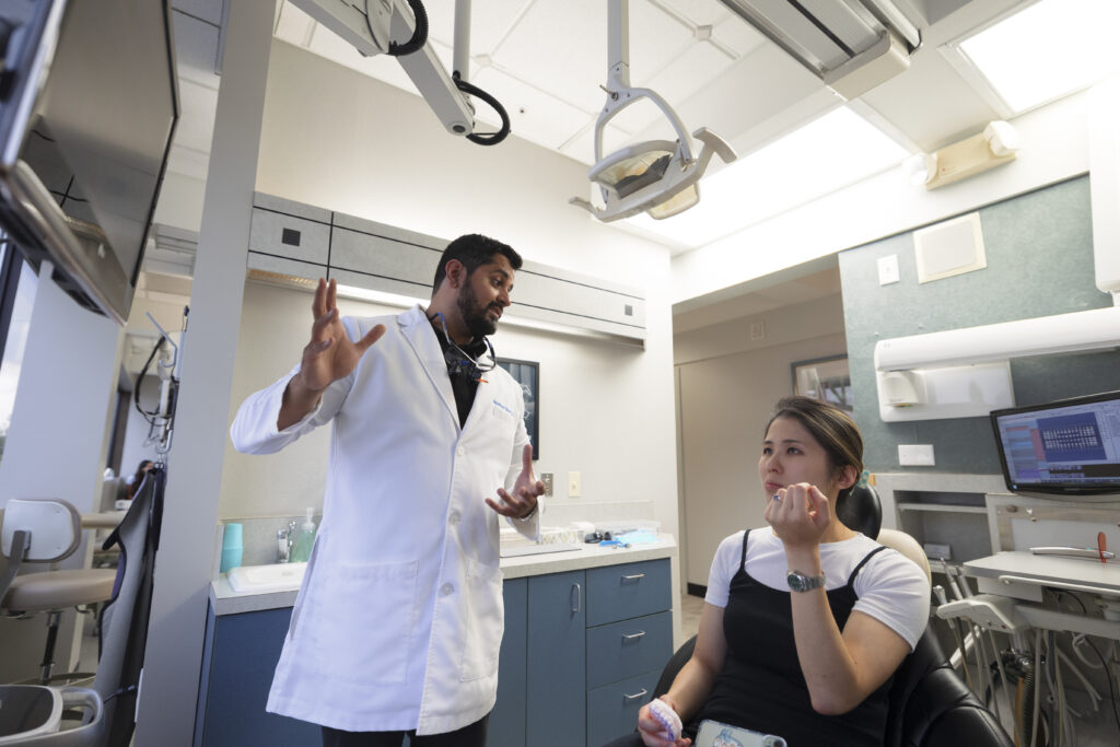 Bearded dentist talking to a patient