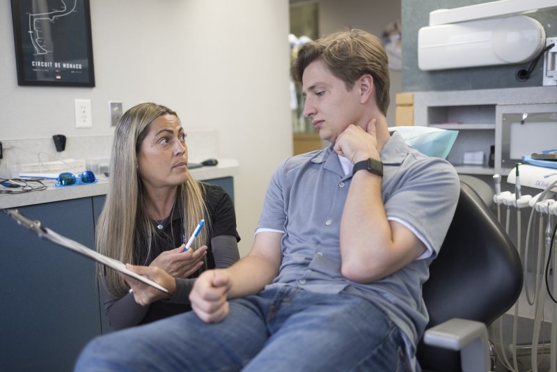 A dental hygienist listening to her patient's feedback